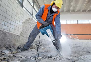 Homem quebrando o solo com um equipamento de perfuração - Guaru-Lok